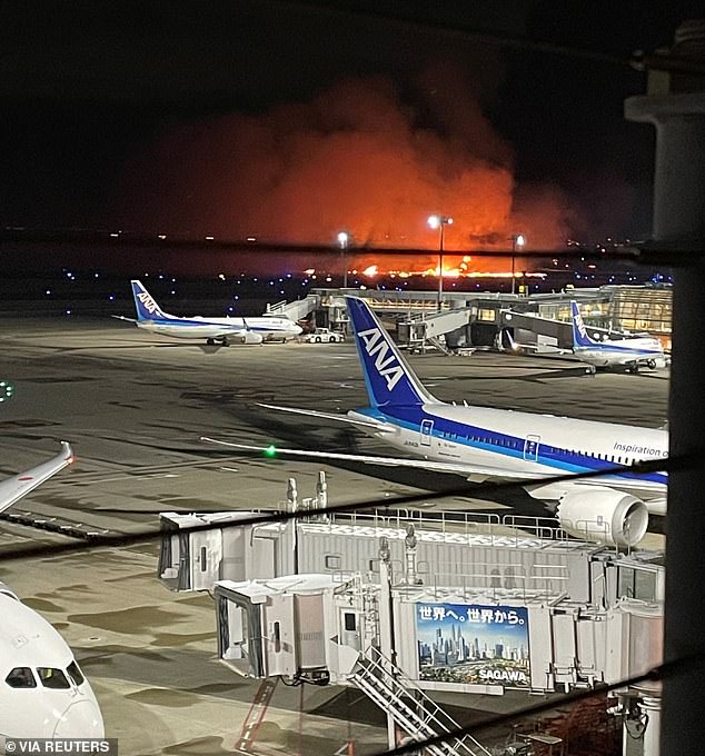 A view from the airport shows flames rising after the Japan Airlines (JAL) plane collision.