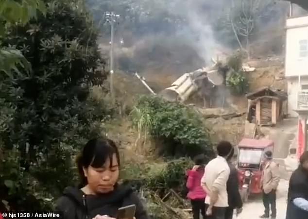 Huge pieces of rubble lie literally meters away from a house, as bystanders gather in amazement