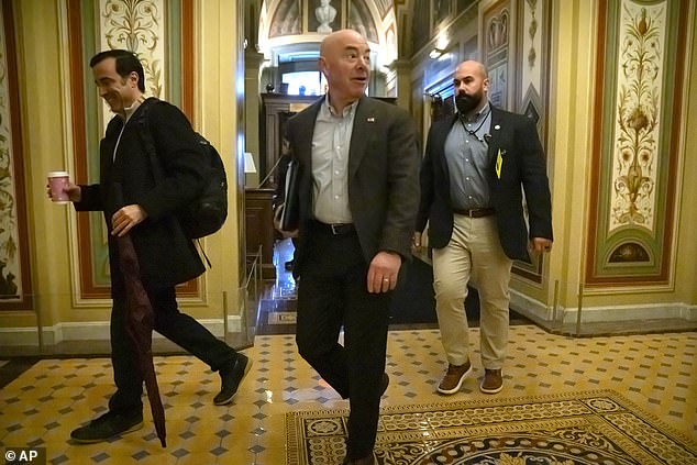 Homeland Security Secretary Alejandro Mayorkas, center, arrives for closed-door negotiations on a border security deal at the Capitol on December 17