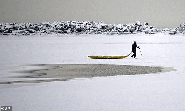 A man walks across the frozen sea in southern Helsinki on Tuesday