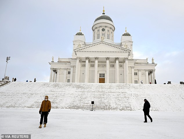 People walk on Senate Square near Helsinki Cathedral amid cold weather in Helsinki