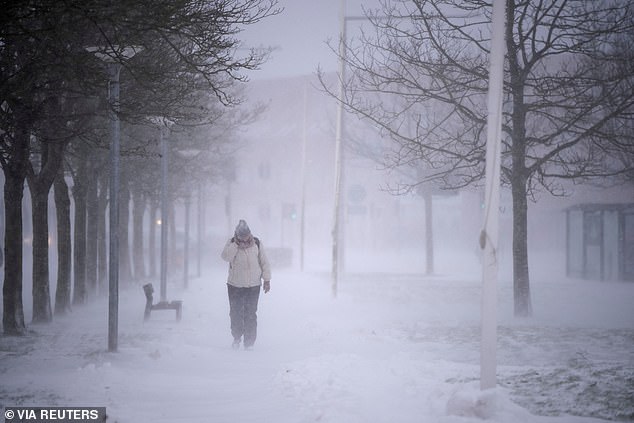 A person walks amid heavy snow in Randers, Denmark, January 3