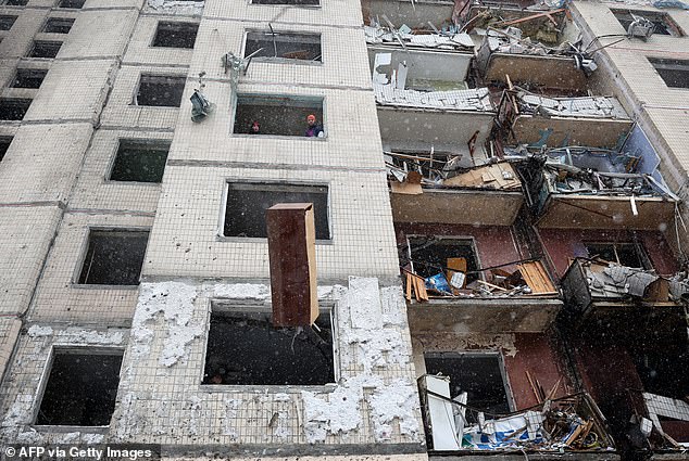 Local residents throw furniture out of the window of a destroyed high-rise building after a Russian missile attack in central Kiev, January 3, 2024