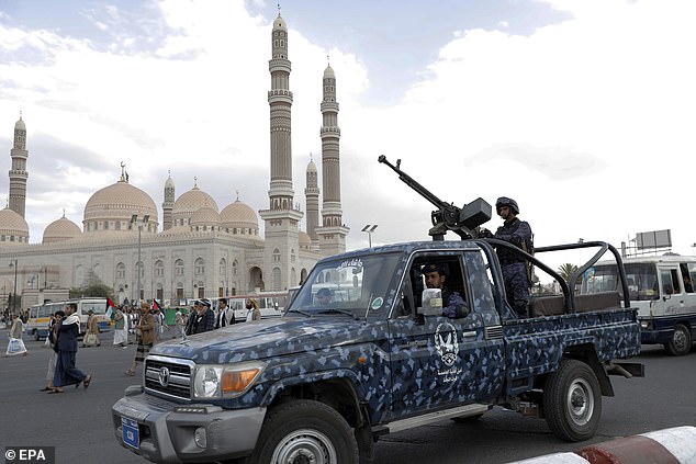 Houthi forces stand guard during a protest against a multinational operation to protect shipping in the Red Sea and in solidarity with the Palestinian people, in Sana'a, Yemen