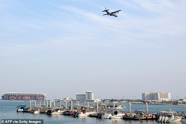 A plane flies over the marina over the water from the 974 Stadium in Doha, Qatar on December 24, 2023