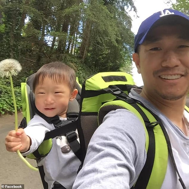 The father and son duo are seen backpacking along a wooded trail as the youngster laughs while holding a flower they picked