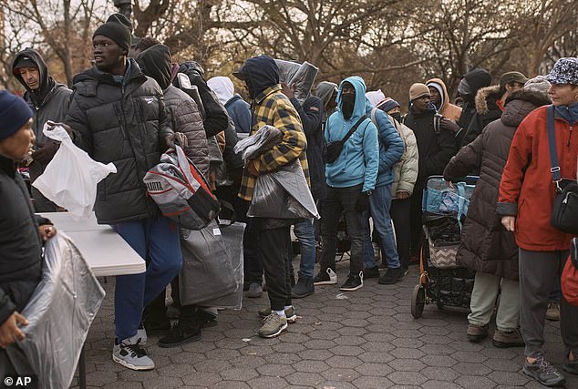 More and more asylum seekers stand outside in the cold picking up blankets in downtown New York City