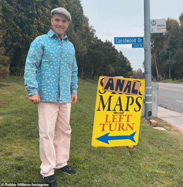 Robbie then stepped back and stood next to his creation, smiling broadly and proudly after carefully covering the word 'Star' with a cardboard sign that read 'Anal'.