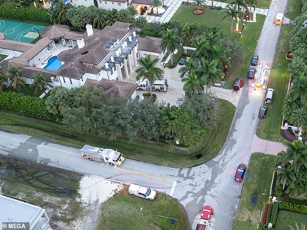 Fire trucks surround the $6.9 million mansion after managing to extinguish the blaze