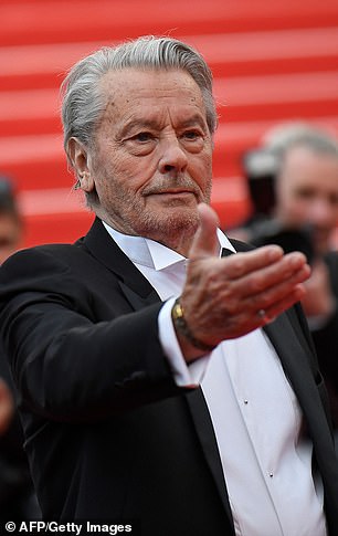 Alain Delon poses as he arrives to receive a Palm of Honor at Cannes in May this year