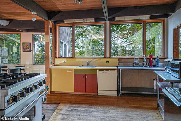 The kitchen features updated appliances, but still retains much of the rustic log cabin feel