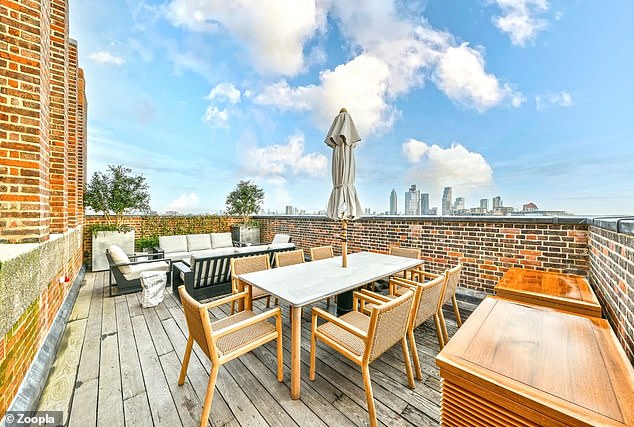 This rooftop terrace at the property has a dining area and a separate seating area with city views