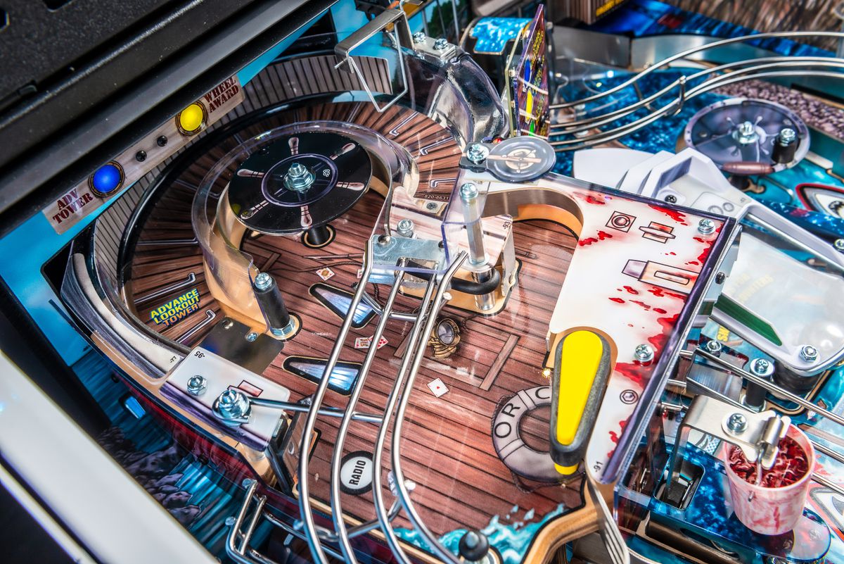 A close-up photo of the Jaws pinball game field, focused on the elevated play field representing the Orca fishing boat and observation tower