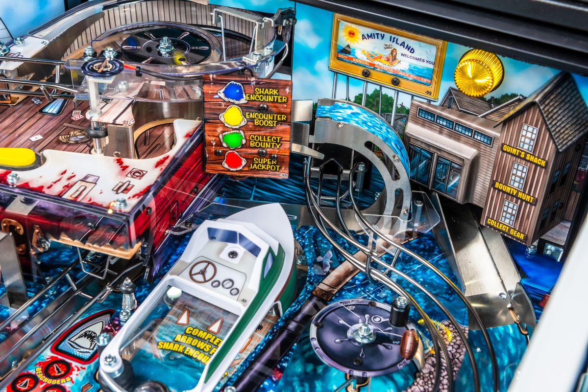 A close-up photo of the Jaws pinball playing field, focused on the undulating slope leading to the Orca fishing boat's elevated playing field