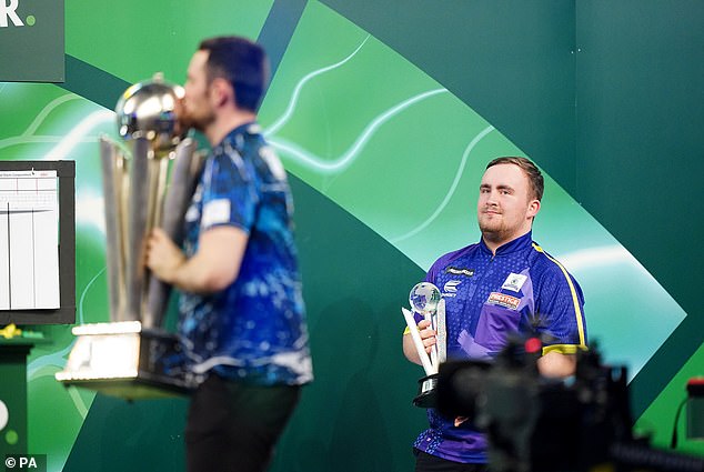 Littler watches as Humphries lifts the trophy after the thrilling final, in which the world number 1 won 7-4