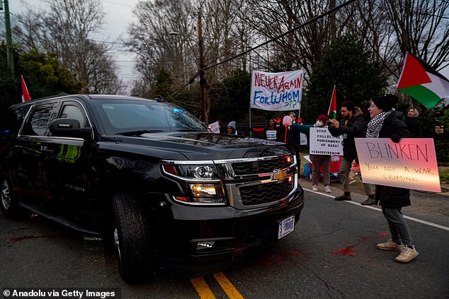 Activists surrounded his SUV as it rolled through the gates of his McClean home and spilled red paint on the driveway as he left for work