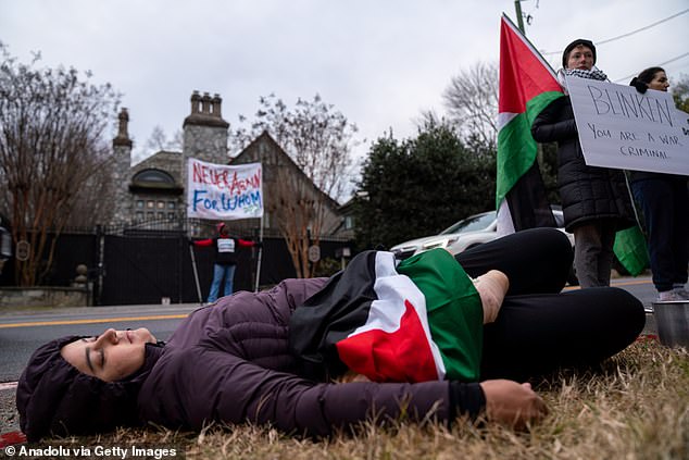 A woman lies on the ground pretending to be dead during the protest against the Biden administration's Israeli policies at Blinken's home