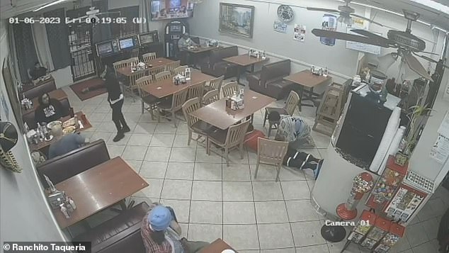 Diners can be seen scattered anxiously on the floor as the robber walks around with the fake gun