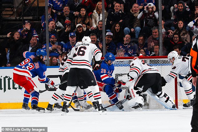 A tangle of bodies caused Chris Kreider (20) to deflect the puck off his skate into the net