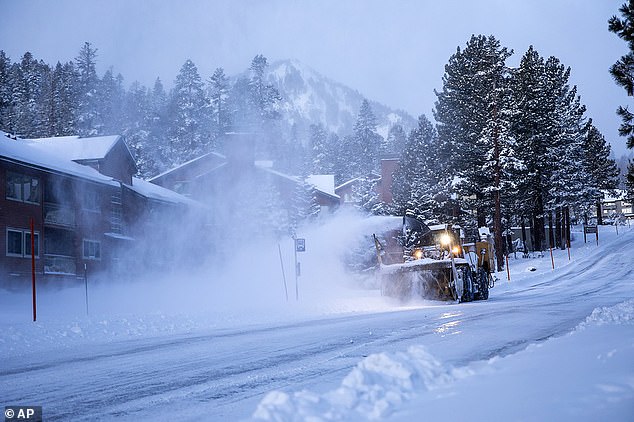 A snow plow clears a road in Mammoth Lakes on Wednesday, January 3, 2024 - California experienced record high snow amounts last winter