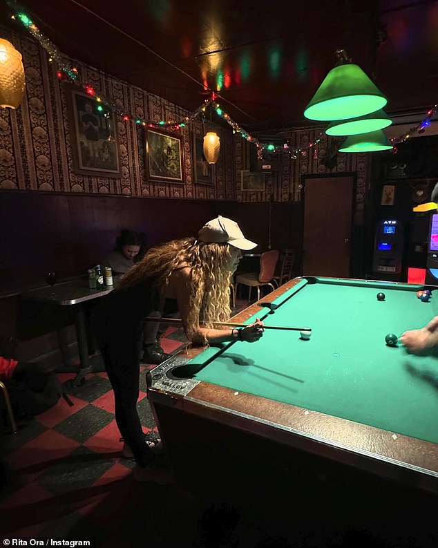 The singer sat back with friends as she played pool