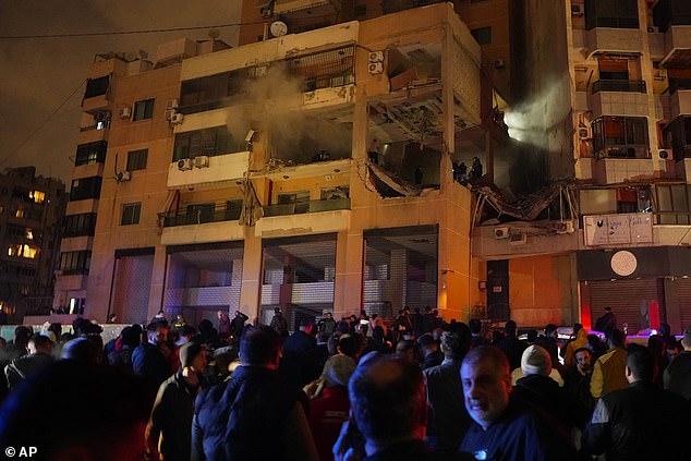 People gather outside a damaged building after a massive explosion in the southern Beirut suburb of Dahiyeh, Lebanon, on Tuesday.  The suspected Israeli attack killed Saleh al-Arouri – the deputy head of the Iran-backed group – showing that Israel is not afraid to strike targets outside the Palestinian areas of Gaza and the West Bank.