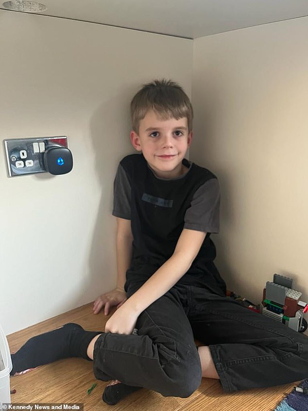 Jackson, seven years old, pictured next to the doorbell receiver installed in his room