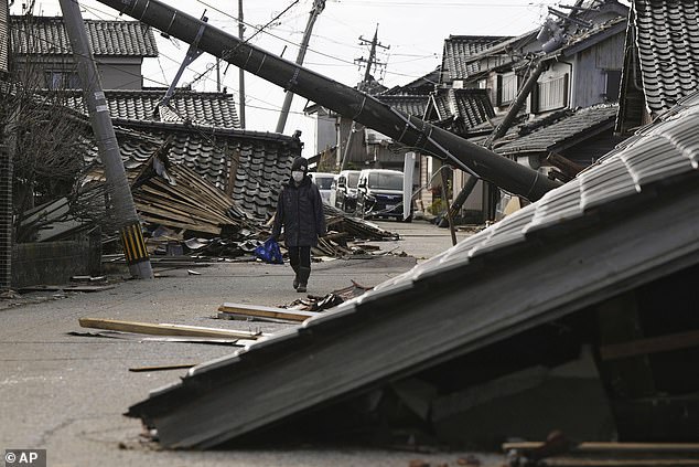 A woman walks through the rubble of a deadly earthquake in Suzu, Ishikawa Prefecture