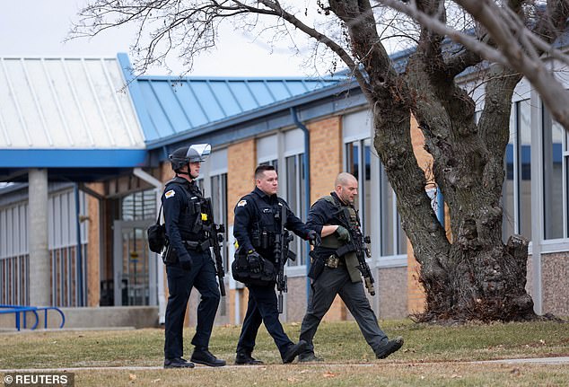 Law enforcement officers work the scene of a shooting at Perry High School in Perry, Iowa