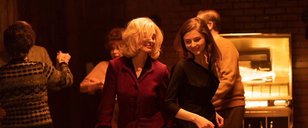 (L-R) Anne Hathaway and Thomasin McKenzie in Eileen.