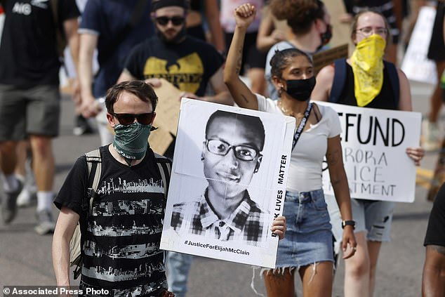 A protester carries an image of Elijah McClain during a rally and march in the summer of 2020