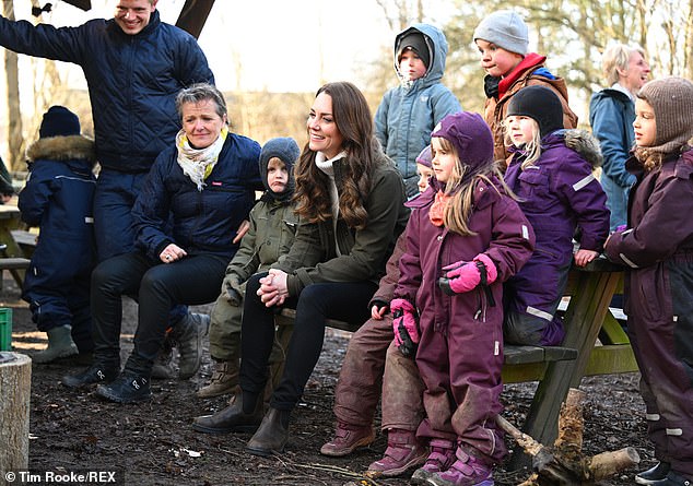 The mother-of-three takes a seat next to a group of children as they take part in a range of activities during the day out in Copenhagen