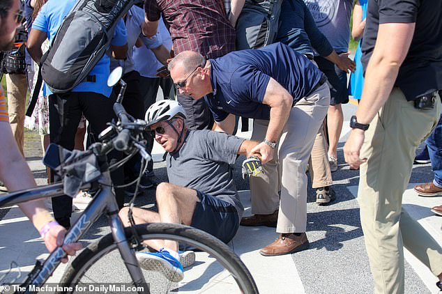 After about 10 seconds on the concrete, Biden was able to hoist himself up with the help of his security staff, drawing applause from the spectators