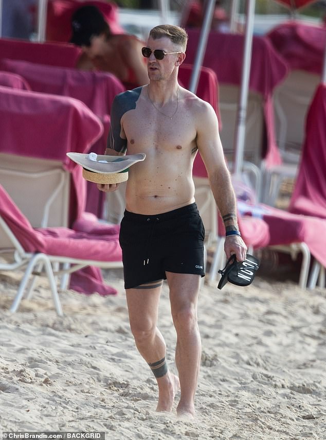 The former England goalkeeper, 36, showed off his abs as he headed shirtless on the lavish trip