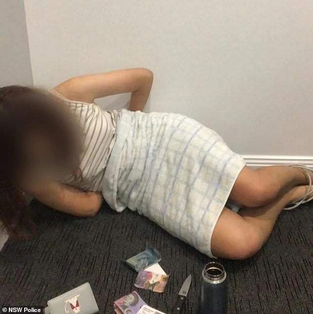 The images are shocking: a young woman lies on the floor, a blindfold over her eyes, her hands apparently tied behind her back, with a large kitchen knife placed menacingly in front of her.