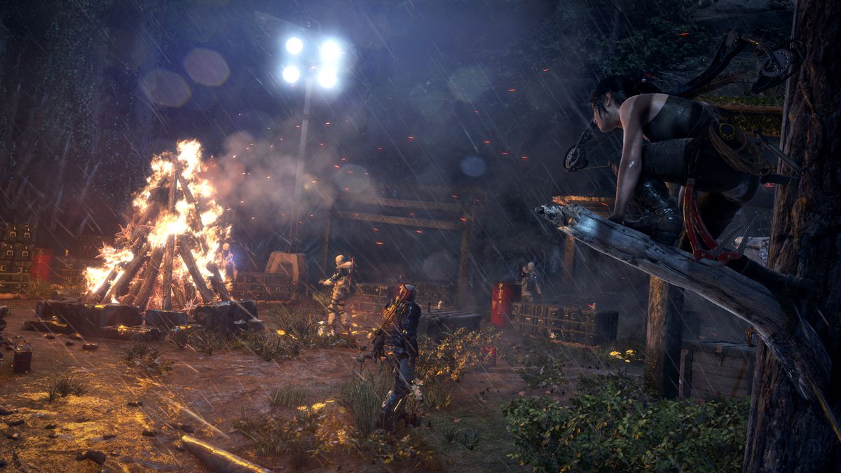 Lara Croft sat on a tree branch overlooking an enemy camp in Rise of the Tomb Raider.