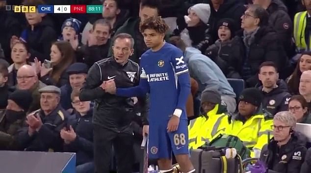 The referee shakes his hand for the second time before letting him onto the field for his debut