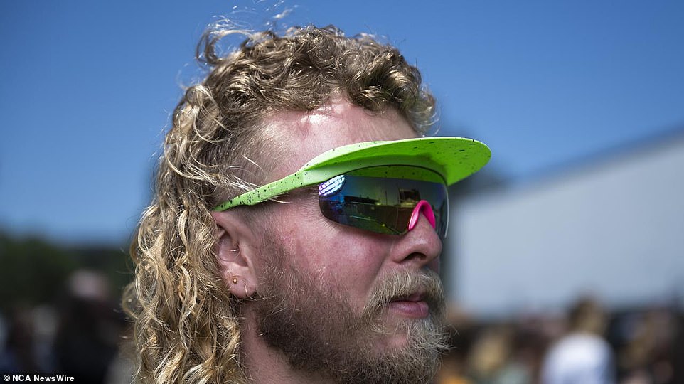 A festival goer pairs a statement visor with large sunglasses as he attends Summernats