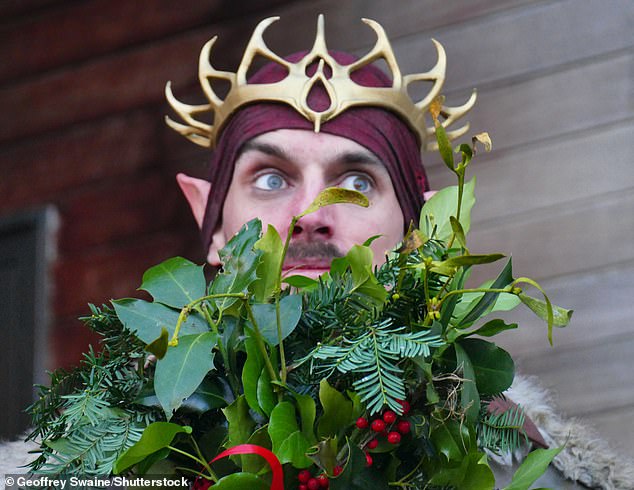 The traditional Anglo-Saxon festival is held in the hope of a full harvest in the coming year.  In the photo: a man takes part in the Wassail ceremony, wearing a crown and holding a bouquet of different leaves