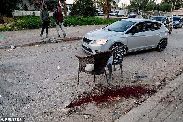 Palestinians in a car check the site where six men were killed in an Israeli airstrike