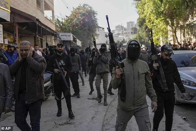 Palestinian gunmen attend the funeral of six Palestinians in the West Bank city of Jenin on Sunday