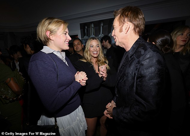 The party takes place shortly after Margot addresses the Saltburn bath scene, which is one of the few moments in the film that has left viewers reeling (pictured with Greta Gerwig and Nicolas Cage)