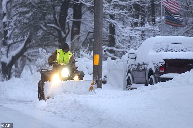 A man plows a snow-covered driveway in Derry, New Hampshire on Sunday.  Portsmouth, New Hampshire and Sanford, Maine collected 12 to 18 inches of snow