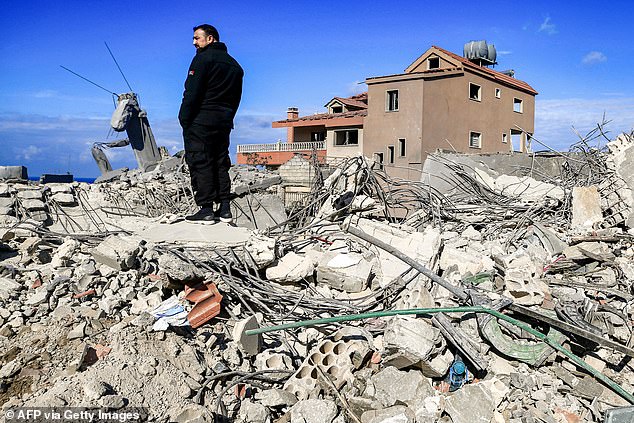 A man stands amid the rubble of destroyed buildings after attacks on the town of Naqura in southern Lebanon