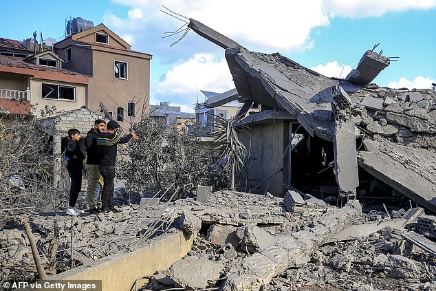 People inspect the rubble of destroyed buildings after attacks on the town of Naqura in southern Lebanon