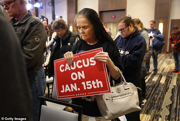 A woman planning to host a rally for Donald Trump prays at an event in Iowa