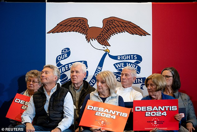 Spectators listen as Republican presidential candidate Florida Governor Ron DeSantis speaks during a campaign event in Waukee, Iowa