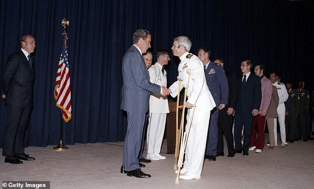 During a pre-dinner reception, US President Richard Nixon (1913 - 1994) shakes hands and greets former North Vietnamese prisoner of war Captain John McCain, Washington DC, May 24, 1973