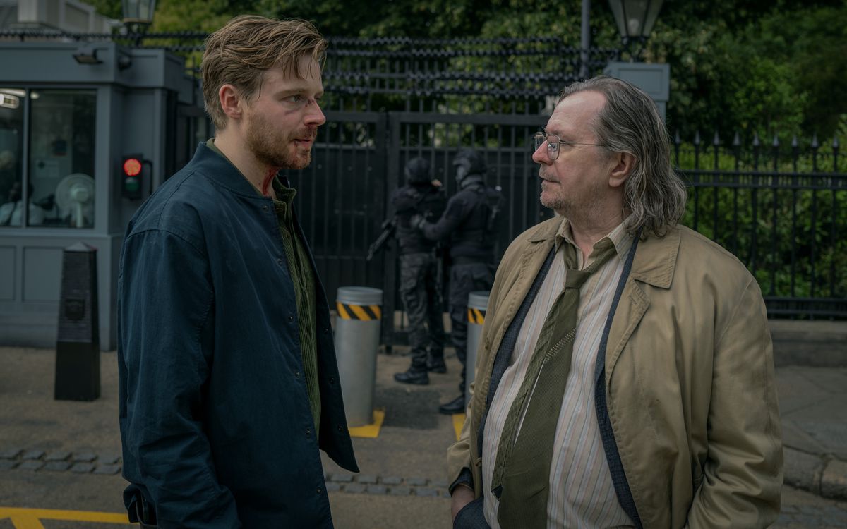 Jack Lowden and Gary Oldman talk outside a secure area in Slow Horses