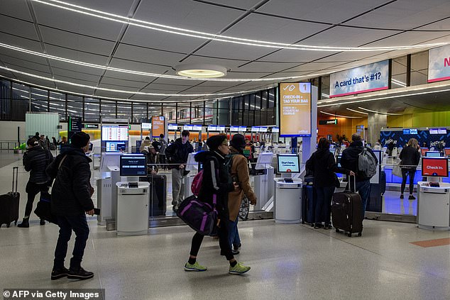 People check in for their flights at Boston Logan Airport on Sunday